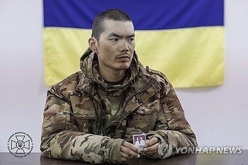 (키이우 EPA=연합뉴스) 9일(현지시간) 우크라이나군에 생포된 중국인 남성이 우크라이나 당국에 심문을 받으면서 가족 사진을 보여주고 있다. 2025.04.10 [우크라이나 보안 당국 제공. 재판매 및 DB 금지]