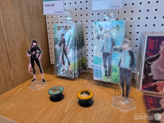 카페 입구 왼편으로 시선을 돌려보면 굿즈들이 전시되어 있다. 테러맨, 테러대부활, 정글쥬스, 하우스키퍼 등 와이랩(YLAB) 관련 IP들의 굿즈가 전시되어 있다. 일부 굿즈들은 이번 카페에서 처음 선보이는 굿즈로, 현장에서 직접 실물을 보고 구매할 수 있다.