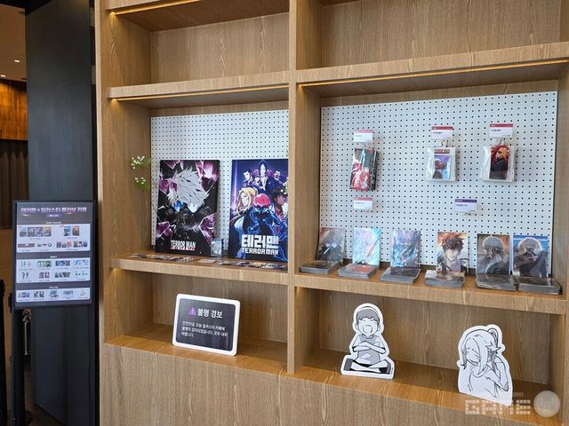 카페 입구 왼편으로 시선을 돌려보면 굿즈들이 전시되어 있다. 테러맨, 테러대부활, 정글쥬스, 하우스키퍼 등 와이랩(YLAB) 관련 IP들의 굿즈가 전시되어 있다. 일부 굿즈들은 이번 카페에서 처음 선보이는 굿즈로, 현장에서 직접 실물을 보고 구매할 수 있다.