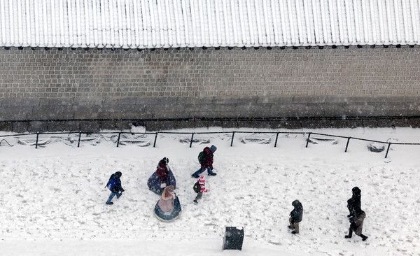 ▲ 지난 25일 서울 종로구 경복궁에 하얀눈이 내리며 화이트 크리스마스를 즐기는 시민들이 휴일 나들이를 하고 있다. 사진=뉴시스