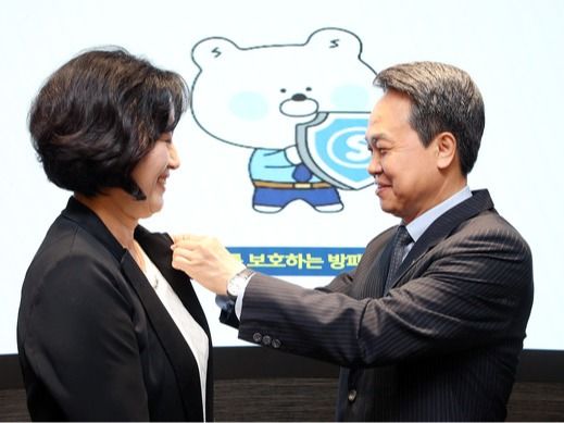 ▲ 이날 행사에 참석한 (사진 오른쪽)진옥동 신한금융그룹 회장이 박현주 신한금융지주 부사장에게 소비자보호 뱃지를 달아주고 있다. 사진=신한금융