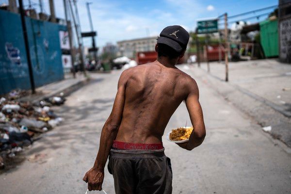 ▲ 지난해 12월 13일(현지시각) 아르헨티나 부에노스아이레스 인근 무료 급식소에서 한 남성이 음식을 받아 들고 가고 있다. 사진=뉴시스