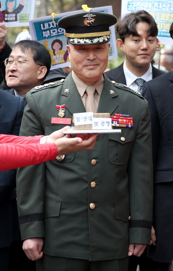 ▲ 채 상병 순직 사건을 수사하다가 보직 해임된 박정훈 대령(전 해병대 수사단장)이 21일 서울 용산구 중앙지역군사법원에서 열리는 항명과 상관 명예훼손 혐의에 관한 결심 공판에 출석하기 앞서 기자회견을 하던 중 해병대 동기들로부터 생일 선물을 받고 있다. 사진=뉴시스