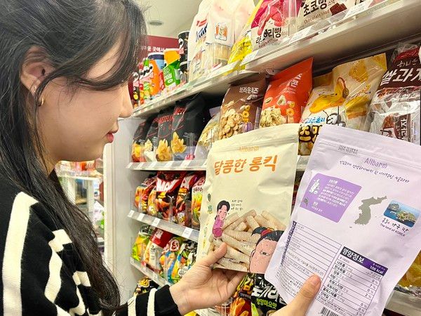 ▲ 한 시민이 GS25 편의점에 진열된 올바름의 독도 쌀과자를 살펴보고 있다. 사진=GS25