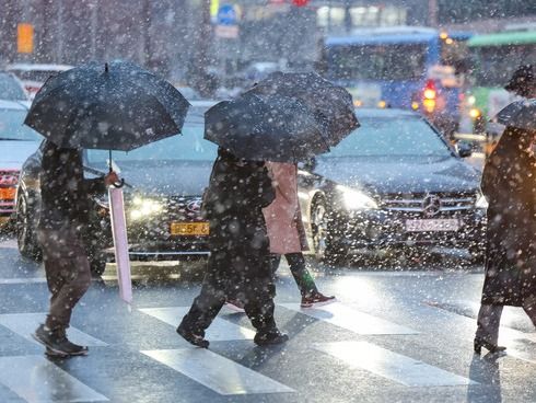▲ 서울 중구의 한 거리에서 시민들이 눈을 맞으며 발걸음을 옮기고 있다. 사진=뉴시스
