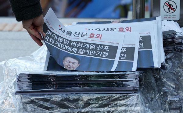 ▲ 한 시민이 비상계엄 관련 호외를 가져가고 있다. 사진=뉴시스