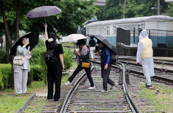 ▲ 서울 등 수도권에 비가 내리기 시작한 26일 서울 노원구 화랑대 철도공원에서 시민들이 우산을 쓰고 사진을 찍고 있다. 2024.05.26. 사진=뉴시스