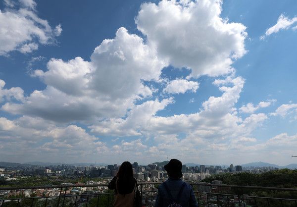 ▲ 맑은 날씨를 보인 8일 오후 서울 종로구 무무대전망대를 찾은 한 시민이 휴대전화로 풍경을 촬영하고 있다. 사진=뉴시스