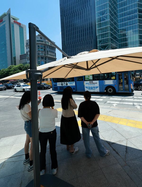 ▲ 26일 서울 강남구 삼성역 앞에 설치된 그늘막에서 시민들이 보행 신호를 기다리고 있다. 사진=뉴시스