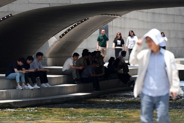 ▲ 전국 대부분 지역에 폭염 특보가 발효된 20일 서울 중구 청계천에서 시민들이 그늘에 앉아 더위를 피하고 있다. 사진=뉴시스