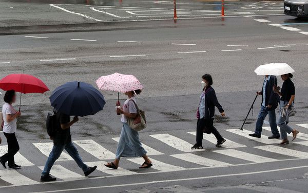▲ 20일 부산 남구의 한 도로에서 시민들이 우산을 쓴 채 횡단보도를 건너고 있다. 사진=뉴시스