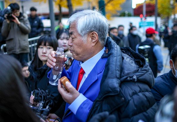 ▲ 특수건조물침입·특수공무집행방해 교사 등 혐의를 받는 전광훈 사랑제일교회 목사가 18일 서울 종로구 서울경찰청으로 피의자 신분 조사를 받기 위해 출석하며 입장을 밝히며 물을 마시고 있다. 사진=뉴시스