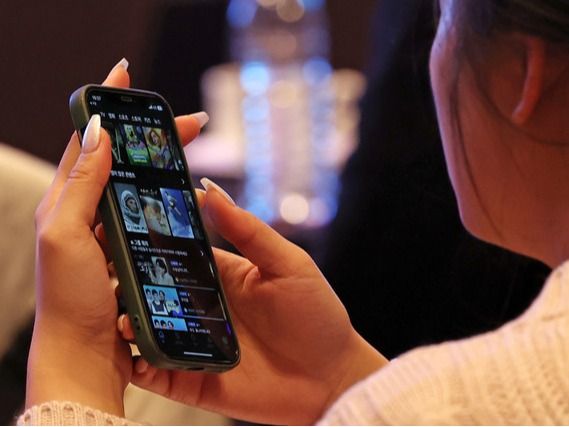 ▲ 서울 중구 앰배서더 서울 풀만 호텔에서 열린 국제 OTT 포럼에서 한 참석자가 휴대폰 OTT 화면을 보고 있다. 사진=뉴시스