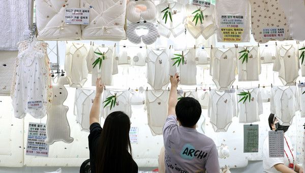 ▲ 지난해 8월 대구 북구 엑스코에서 열린 ‘제41회 대구 베이비&키즈페어’를 찾은 관람객들이 배냇저고리를 살펴보고 있다. 사진=뉴시스