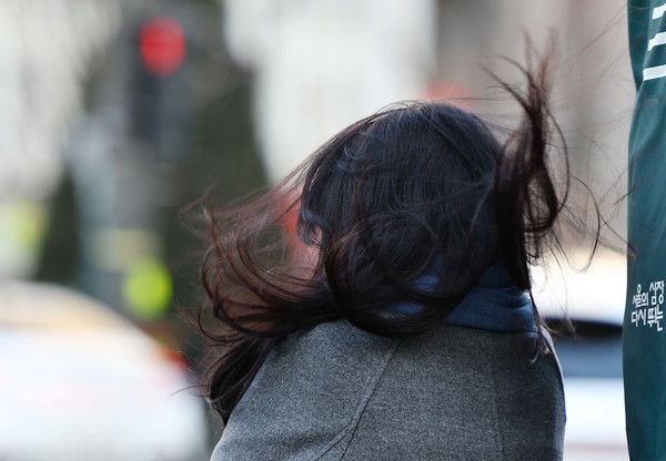 ▲ 서울 광화문 사거리에서 출근길 한 시민의 머리가 바람에 날리고 있다. 사진=뉴시스