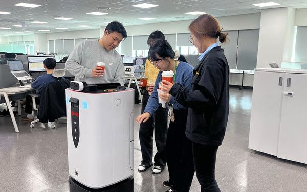 ▲ 현대엘리베이터 임직원들이 14일 오전 승강기-로봇 연동 배달 서비스를 통해 음료를 수령하고 있다. 사진=현대엘리베이터