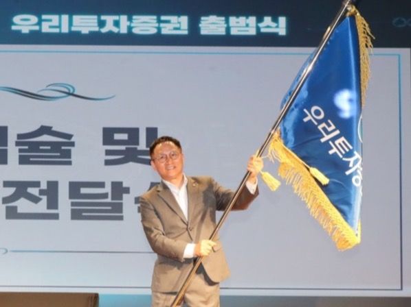 ▲ 남기천 우리투자증권 대표가 지난해 8월 진행된 우리투자증권 출범식에서 회사기를 흔들고 있다. 사진=우리투자증권