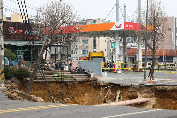 ▲ 25일 오전 서울 강동구 명일초등학교 인근 도로에서 전날 발생한 싱크홀(땅 꺼짐) 사고 현장이 통제되고 있다. 사진=뉴시스