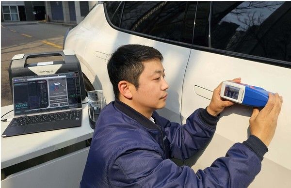 ▲ KCC 관계자가 칼라나비플러스(Color-Navi Plus)를 활용해 자동차 외장을 측색하며 테스트를 하고 있다 사진=KCC