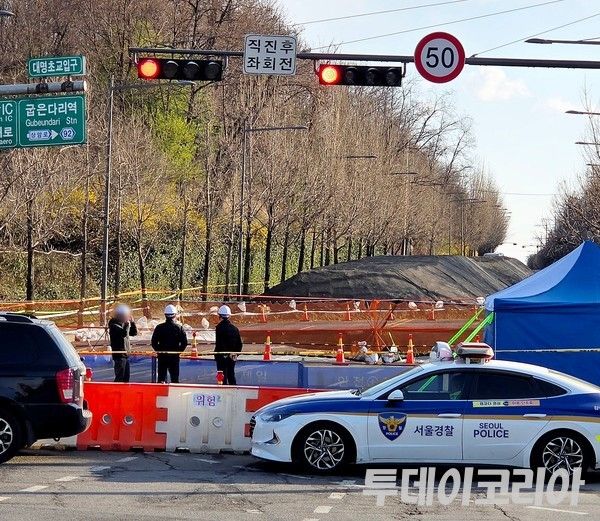 ▲ ▲ 30일 관계자들이 서울 강동구 대명초등학교 인근 사거리에 생긴 싱크홀(땅꺼짐) 현장을 점검하고 있다. 이번 싱크홀은 가로 18m, 세로 20m, 깊이 약 20m 규모로 왕복 6차선 중 4차선에 걸쳐 발생했다. 사진=투데이코리아