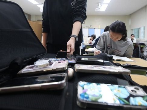 ▲ 지난 10월 15일 대구 수성구 정화여고 3학년 교실에서 학생들이 전국연합학력평가 시험을 치르기 위해 휴대전화를 수거용 가방에 제출하고 있다. 사진=뉴시스