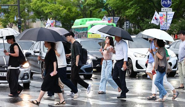 ▲ 서울 종로구 세종대로에서 시민들이 비를 피해 퇴근하고 있다. 사진=뉴시스