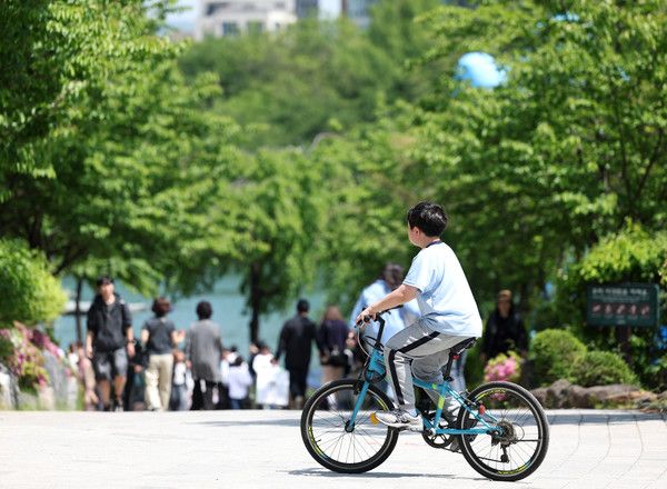 ▲ 서울 송파구 석촌호수에서 한 어린이가 자전거를 타고 있다. 사진=뉴시스