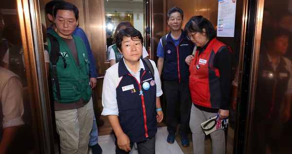 ▲ 10일 밤 세종시 정부세종청사에서 이미선 민주노총 부위원장 등 민주노총 추천 근로자위원들이 공익위원이 제시한 심의촉진구간에 반발, 집단 퇴장하고 있다. 사진=뉴시스