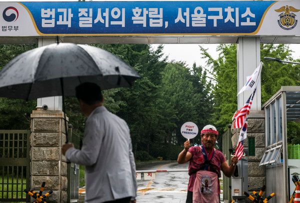 ▲ 내란 특검 2차 소환에 불응한 윤석열 전 대통령에 대한 강제 구인 절차에 돌입한 14일 오후 경기 의왕시 서울구치소 앞에서 윤 전 대통령 지지자가 태극기와 성조기를 들고 있다. 사진=뉴시스