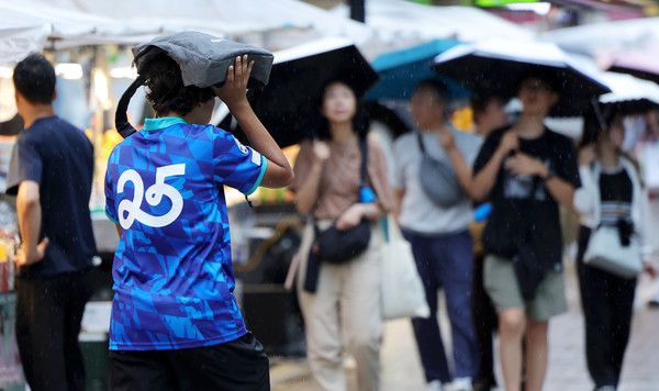 ▲ 서울 중구 명동 거리를 찾은 관광객이 가방으로 머리를 가린 채 발걸음을 옮기고 있다. 사진=뉴시스