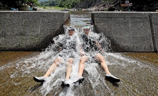 ▲ 경북 청도군 운문사 인근 계곡을 찾은 피서객들이 시원한 물줄기를 맞으며 더위를 식히고 있다. 사진=뉴시스
