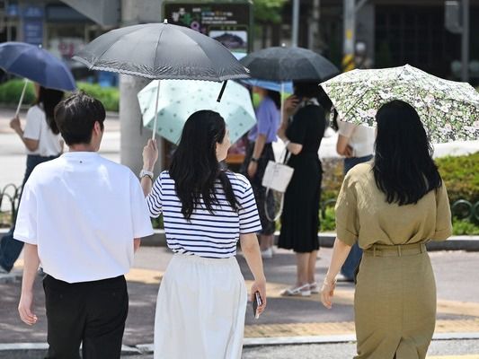 ▲ 광주 북구청 사거리에서 시민들이 양산을 쓴 채 걷고 있다. 사진=뉴시스