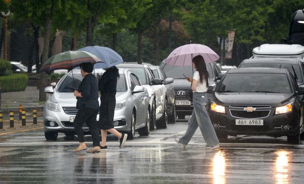 ▲ 전주시 백제대로에서 시민들이 우산으로 비를 피하며 길을 지나고 있다. 사진=뉴시스