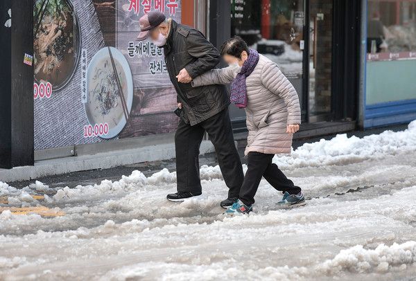 ▲ 28일 경기 의왕시 도깨비시장 인근에서 한 노부부가 손을 잡고 빙판길을 걷고 있다. 2024.11.28. 사진=뉴시스