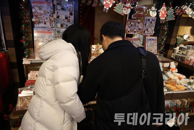▲ 연말 분위기로 꾸며진 크리스마스마켓에서 방문객들이 진열품들을 살펴보고 있다. 사진=투데이코리아