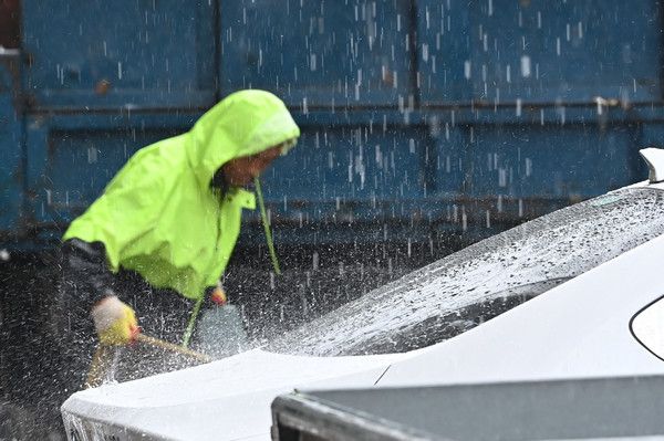 ▲ 환경미화원이 비를 맞으며 종이박스를 차량에 싣고 있다. 사진=뉴시스