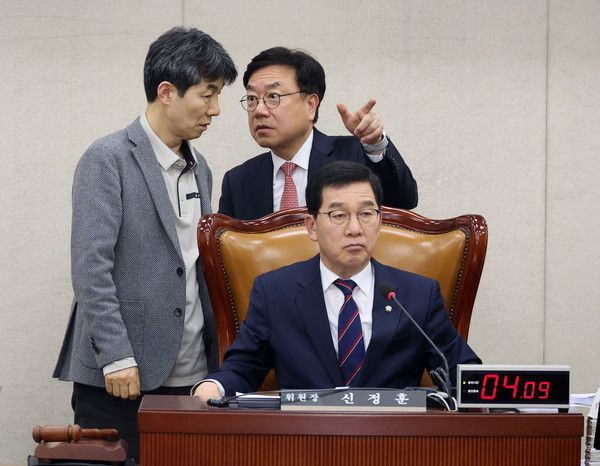 ▲ 윤건영(왼쪽) 국회 행정안전위원회 여당 간사와 서범수(오른쪽) 야당 간사가 12일 오후 서울 여의도 국회에서 행정통합 의결을 위해 열린 전체회의에서 쟁점을 두고 논의를 하고 있다. 가운데는 신정훈 위원장. 사진=뉴시스