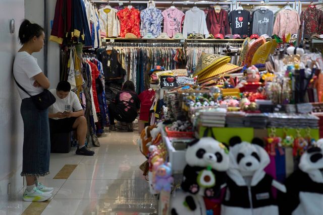 ▲ 베이징의 한 쇼핑몰의 의류와 기념품 매장에서 상인들이 손님을 기다리고 있다. 사진=뉴시스