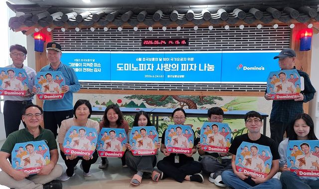 ▲ 도미노피자가 24일 강원도 원주시에 위치한 원주보훈요양원을 방문해 참전유공자와 국가유공자들에게 피자를 전달하고 기념촬영을 하고 있다. 사진=도미노피자