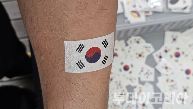 ▲ 25일 ‘호국보훈의 달 기념주간’에서 마련된 참전국 타투스티커 부스에서 한 시민이 태극기가 그려진 스티커를 팔에 붙이고 있다. 사진=이기봉 기자
