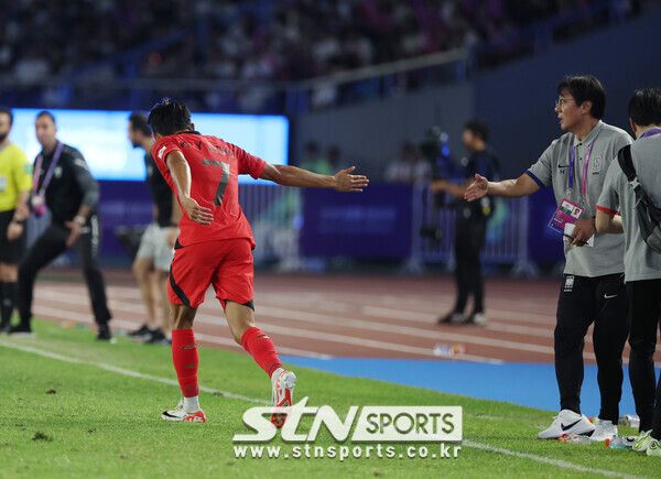 4일 중국 항저우 황룽스포츠센터 스타디움에서 열린 2022 항저우 아시안게임 남자 축구 준결승 한국 대 우즈베키스탄 경기, 전반전 한국 정우영이 추가골을 넣고 황선홍 감독과 인사를 하고 있다. 사진┃뉴시스