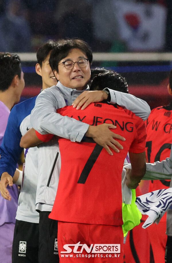 7일 중국 항저우 황룽스포츠센터 스타디움에서 열린 2022 항저우 아시안게임 남자 축구 결승 한국 대 일본 경기, 한국이 일본을 꺾고 금메달을 획득했다. 황선홍 감독이 선수들을 안으며 기뻐하고 있다. 사진┃뉴시스