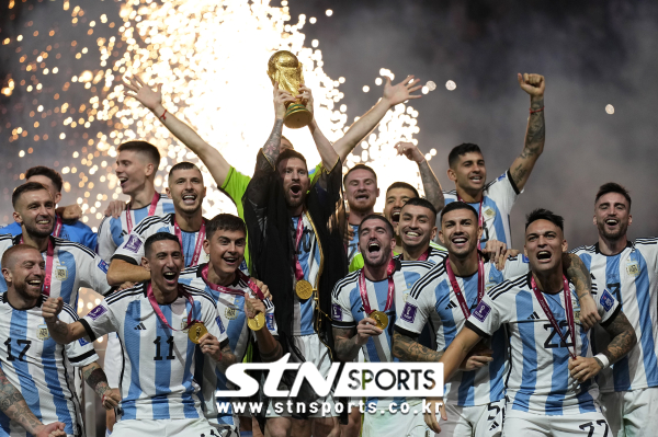 아르헨티나의 리오넬 메시가 18일(현지시간) 카타르 루사일 스타디움에서 열린 2022 카타르 월드컵 정상에 올라 우승컵을 들고 동료들과 기념사진을 찍으며 환호하고 있다. 아르헨티나는 연장 3-3 무승부 끝에 승부차기로 프랑스를 4-2로 꺾고 36년 만에 정상에 올랐다. 사진｜뉴시스/AP