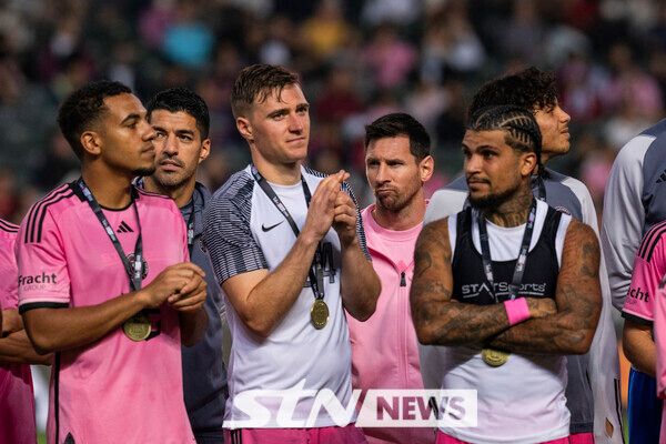 리오넬 메시와 루이스 수아레스가 4일(현지시각) 홍콩 스타디움에서 열린 홍콩 축구 대표팀과의 친선 경기를 마친 후 팬들에게 인사하는 동료들 뒤에 서 있다. 이날 메시와 수아레스가 부상을 이유로 예고 없이 결장해 축구 팬들의 분노와 비난을 샀다. 사진┃뉴시스