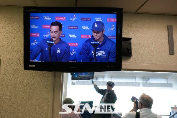 로스앤젤레스 다저스의 오타니 쇼헤이(오른쪽)가 25일(현지시각) 미 캘리포니아주 로스앤젤레스의 다저스타디움에서 새 통역사 윌 아이레튼과 함께 기자회견 하는 모습이 모니터로 송출되고 있다. 오타니는 “(통역사) 미즈하라가 도박 빚을 갚기 위해 내 계좌에서 돈을 훔친 것”이라며 “내게 거짓말을 했기 때문에 난 전혀 몰랐다”라고 입장을 밝혔다. 사진┃뉴시스/AP