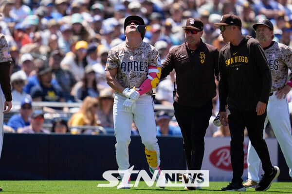 샌디에이고 파드리스의 김하성(왼쪽)이 12일(현지시각) 미 캘리포니아주 샌디에이고의 펫코 파크에서 열린 2024 메이저리그(MLB) LA 다저스와의 경기 4회 말 투구에 손목을 맞고 고통스러워하고 있다. 김하성은 5회 교체됐고 1타수 무안타 1사구를 기록했다. 사진┃뉴시스/AP