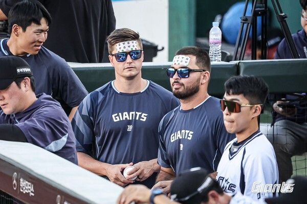 (좌측부터) 터커 데이비슨, 알렉 감보아가 여름 더위를 이기지 못하고 쿨패치를 이마에 붙였다. /사진=롯데 자이언츠