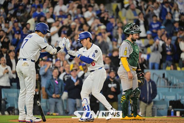 LA 다저스의 김혜성(가운데)이 14일(현지 시간) 미 캘리포니아주 로스앤젤레스의 다저스타디움에서 열린 2025 메이저리그 오클랜드 애슬레틱스와의 경기 5회 말 동점을 기록하는 1점 홈런(시즌 1호)을 친 후 홈에 들어와 오타니 쇼헤이와 하이 파이브를 하고 있다. 사진┃뉴시스/AP
