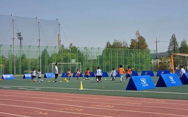 유소년 축구 클리닉에 참여한 유소년 선수들이 훈련에 앞서 김은중 감독의 지도 아래 축구 경기 맞춤형 스트레칭을 하며 몸을 풀고 있다./사진=양주시