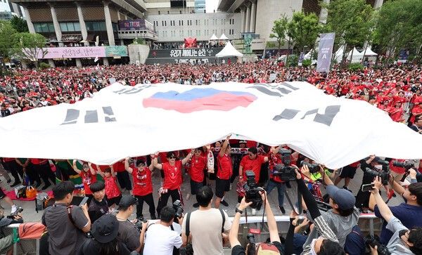 남아프리카공화국전 패배로 자력 32강행이 무산된 홍명보호는 하루 사이 경쟁국들이 잇달아 유리한 결과를 챙기면서 조 3위 경쟁 6위까지 밀려났다. 한국의 운명은 G조부터 L조까지 남은 여섯 개 조 최종전 결과에 달렸다.(▲25일 2026 북중미 월드컵 조별리그 A조 3차전 대한민국과 남아프리카공화국 경기. 서울 종로구 광화문광장에서 시민들이 대형 태극기를 펼지며 승리의 응원을 하고 있다.). /사진=뉴시스